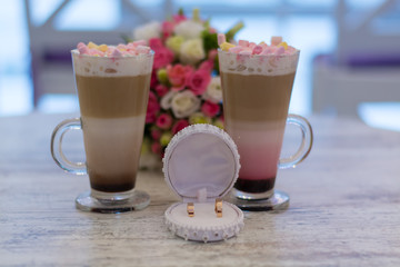 Wedding bouquet of roses on a table with wedding rings and coffee