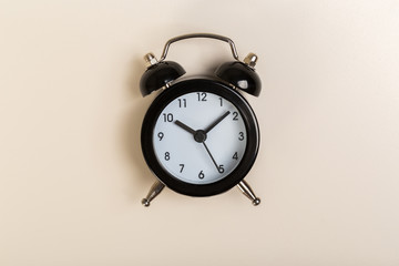 black vintage alarm clock on a colored background, top view. concept of time, daily routine