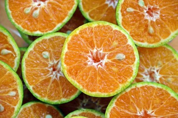 Fresh Asian oranges or tangerines were cut by half, preparing for making orange juice