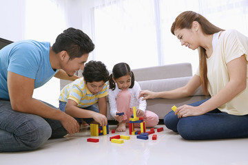 Family of four playing with building blocks