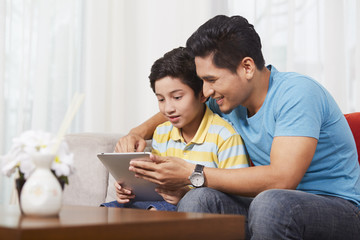 Father and son using a digital tablet together