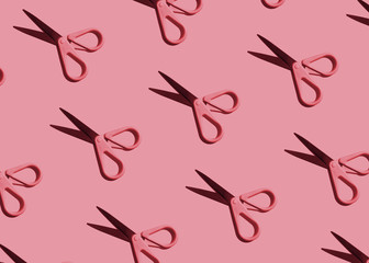 Pink pattern: stationery scissors on pink background flat lay close-up. Hard light.