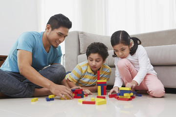 Fototapeta premium Cheerful father playing with his children