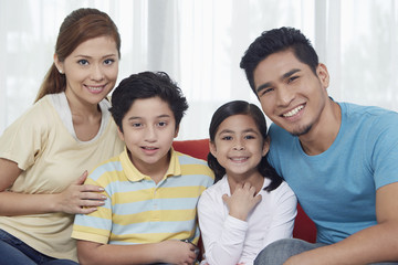 Obraz premium Family of four cheerfully smiling at the camera