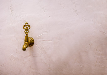 Antique bronze faucet on a white wall