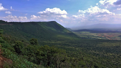 Amazing Great Rift Valley, Kenya. The huge valley is covered with impenetrable jungle. Mountains are visible against the blue sky with beautiful clouds. On earth, shadows from clouds. Picturesque.