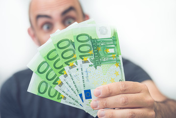 Mann hält 100 Euro Scheine in der Hand