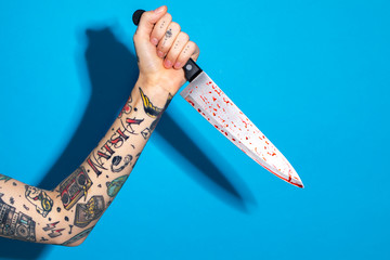 Tattooed hand with a kitchen knife