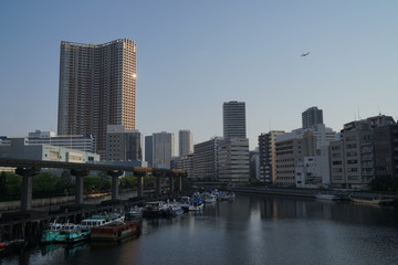 Fototapeta na wymiar 芝浦渚橋からの運河の眺め　羽田空港新航路の機影