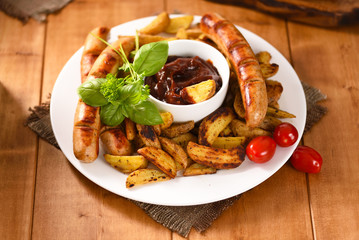 Fried fries with sausages and ketchup. Full, delicious food and not healthy.