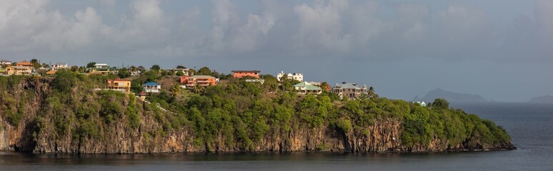Fototapeta na wymiar Beautiful panoramic aerial view of a cliff with some buildings and houses on it on St. Vincent island