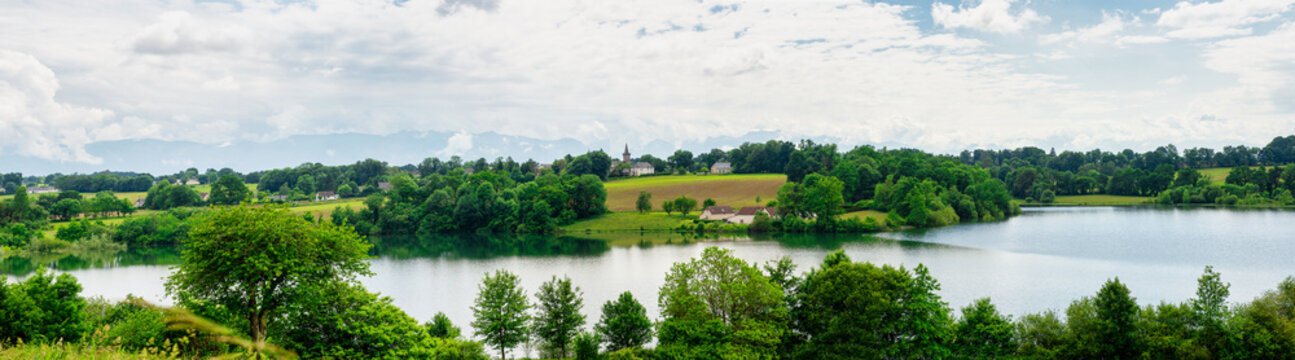 village, small church, lake and french pyrenees mountains background