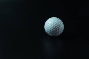 White golf ball on black background with copy space