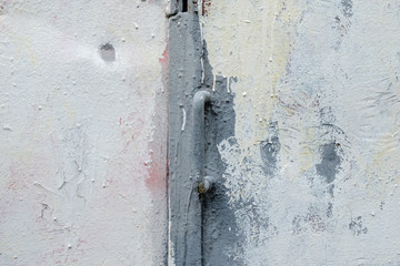 Fragment of an old iron door with a handle painted in gray paint. Drips of dried oil paint on a metal surface. Grunge pattern.