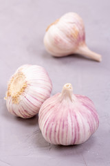 Three heads of garlic close-up on a gray background