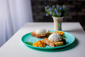 poached eggs lie on a turquoise plate on a background of flowers. 
poached eggs with bread, corn on a plate