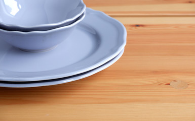 Purple plates on a wooden table. Tableware. Suitable for background.