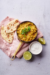 Indian red lentil curry soup dal with rice naan. Vegan indian dish on concrete background with copy space