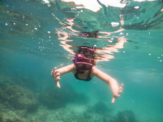 Underwater portrait of a woman snorkeling in tropical sea.