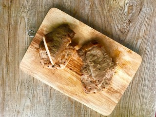 Grilled pork chops, Fried marinated pork steak on wooden background. Top view.