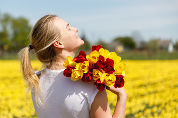 The young woman with tulips in the tulip field