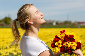 The young woman with tulips in the tulip field