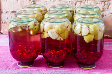 Homemade canned fruit compote for the winter. Compot from apples and red currant. Inverted jars