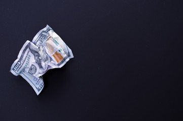 Several 100 dollar bills, falling down, burn on a black background. The concept of bankruptcy, depreciation, devaluation, wastefulness and waste of money. Copy space