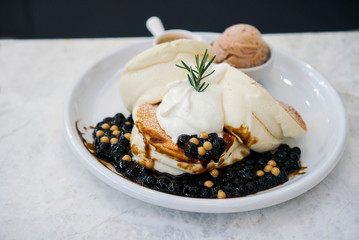 Bubble milk tea souffle pancake. Japanese fluffy pancake topped with fresh cream and bubble/boba pearl with brown sugar syrop, served with milk tea ice cream.