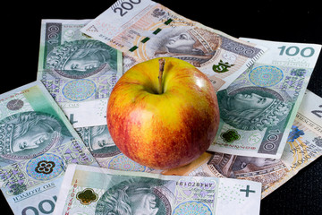 An apple lying on Polish banknotes.