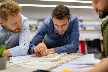 Team of architects working on building model scale