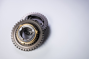New parts on a gray background. Gears of gear shifting torque transmission. Conceptually mechanical background. Shiny gear box gear teeth