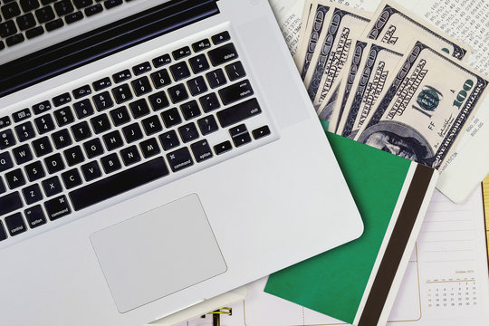 Top View Of Laptop With Book Bank And Banknote On Statement Paper Background.Finance Concept.