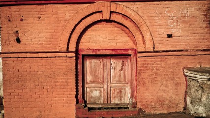 Brick red wall with wooden window door