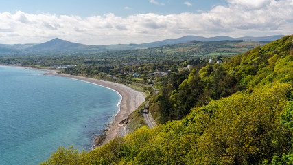 View from Killiney Hill, a popular spot for hill walkers in Dublin, Ireland over the Irish Sea, Killiney Beach and a scenic railroad on a sunny summer day.