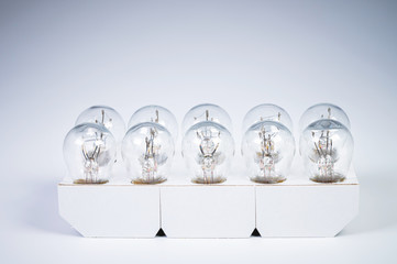 A set of ten light bulbs oversized car lights on a gray gradient background. Paper-packed...