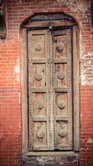 Brown tall wooden door with padlock above