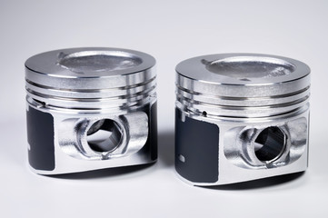 Close-up of two new internal combustion engine piston on a gray gradient background. The concept of...