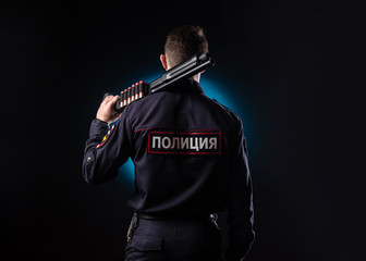 handsome guy in a police officer's uniform with a gun. english translation "Police, Russia, Ministry of internal Affairs"