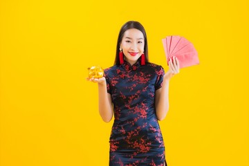 Portrait beautiful young asian woman wear chinese dress show gold piggy bank