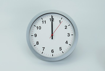 Close up White wall clock isolated on white background, face beginning of time 12.00 am or pm,...