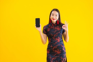 Portrait beautiful young asian woman wear chinese dress use smart mobile phone