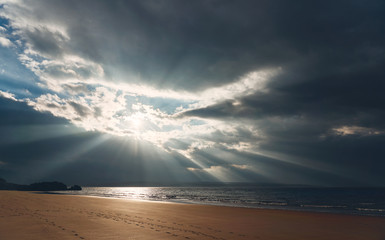 Rays of autumn sunlight breaking through the cloud at the waters edge of Big Sand beach near Gairloch in the Scottish Highlands, Scotland, UK.
