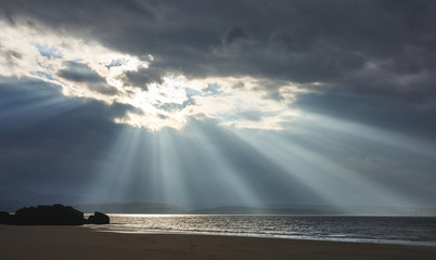 Rays of autumn sunlight breaking through the cloud at the beach of Big Sand near Gairloch in the Scottish Highlands, Scotland, UK.
