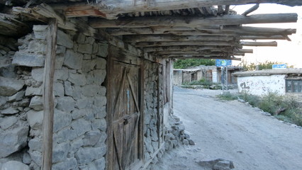 Grey stone wall with wooden door and roofs
