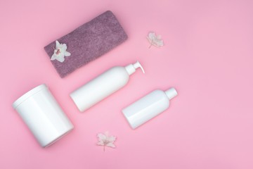 White cosmetic bottles, bottles on a pink background. Layout of lotion, hair mask, gel, soap, shampoo. Minimal style. Beauty and spa concept.