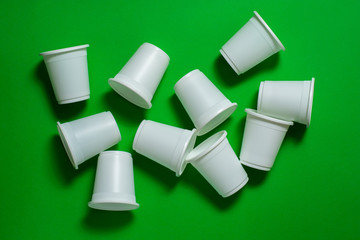 Disposable glasses from environmentally friendly materials on a green background. Biodegradable...