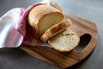 Wheat homemade bread on a wooden desk. Grey background. Horizontal.