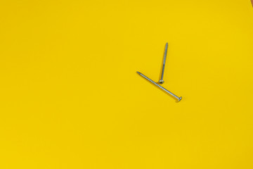 steel screws against a colored background. screws on a yellow background. space for the inscription. space for the site and sale.