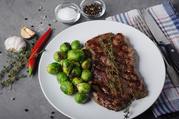 Meat steak with Brussels sprouts, side view